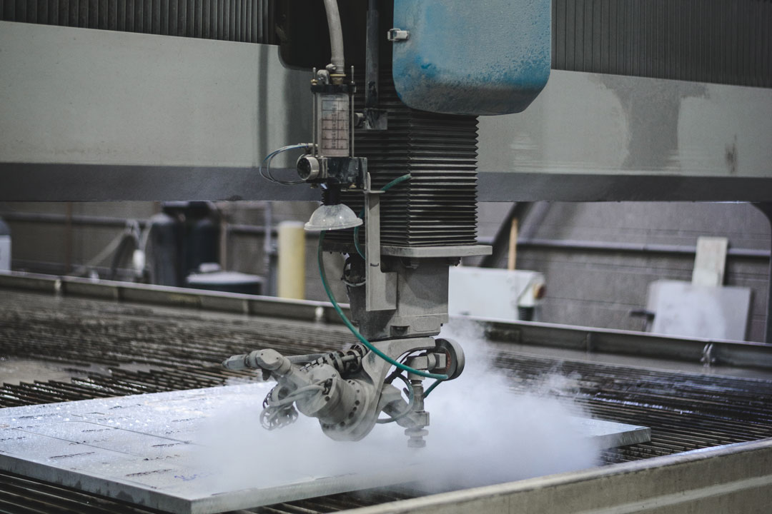 A waterjet cutter cutting a component for large tooling or flight hardware for the aerospace, defense, and space industry