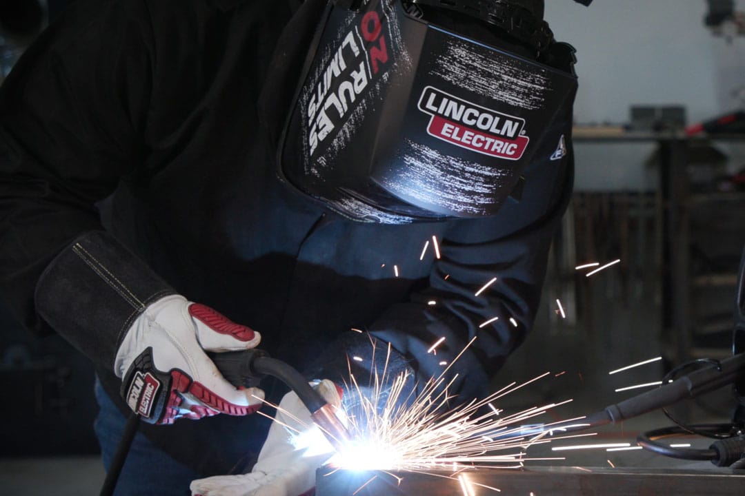A fabricator MIG (GMAW) welding a custom metal component for an architectural application