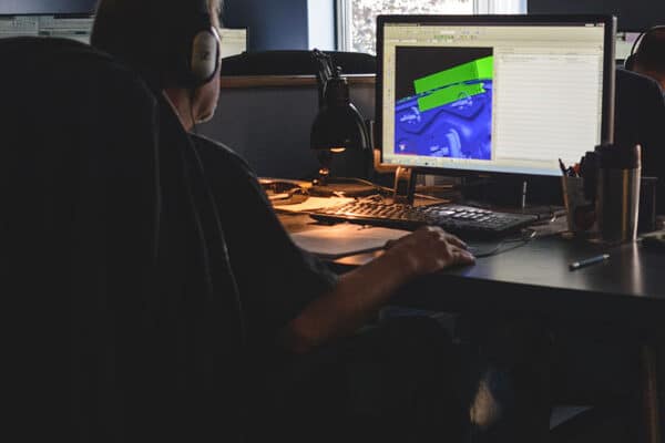 A designer working on a 3D CAD model of tooling