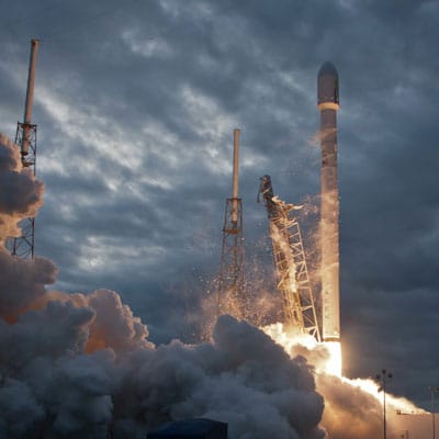 A rocket launching in front of a cloudy sky