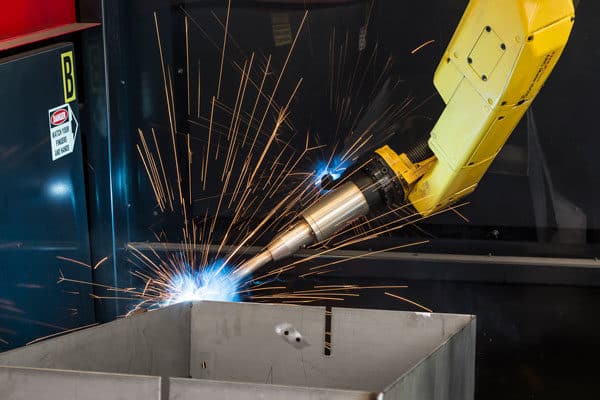 An automated robotic welding system welds a large metal part