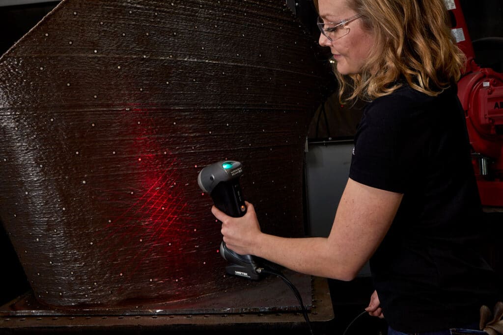 A 3D scanner being used to inspect a large 3D-printed steel section of a sculpture
