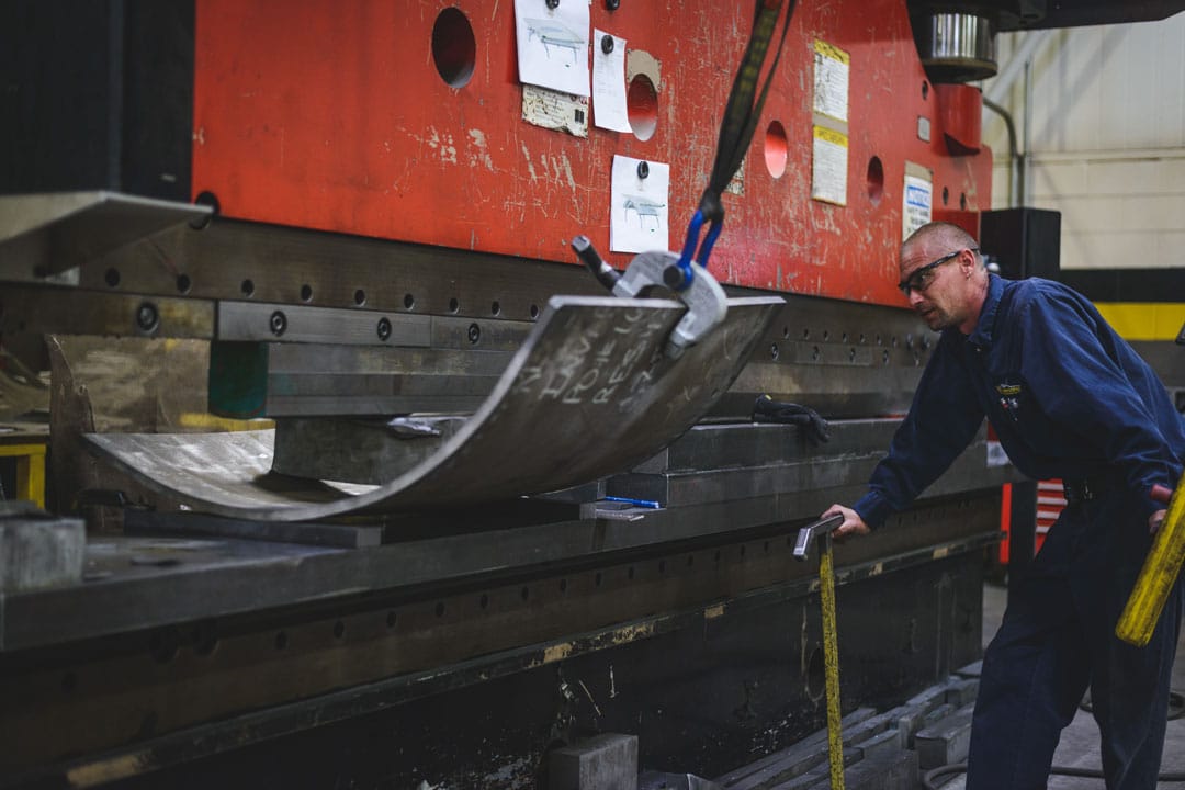 A fabricator using a large press brake to form steel for aerospace tooling fabrication