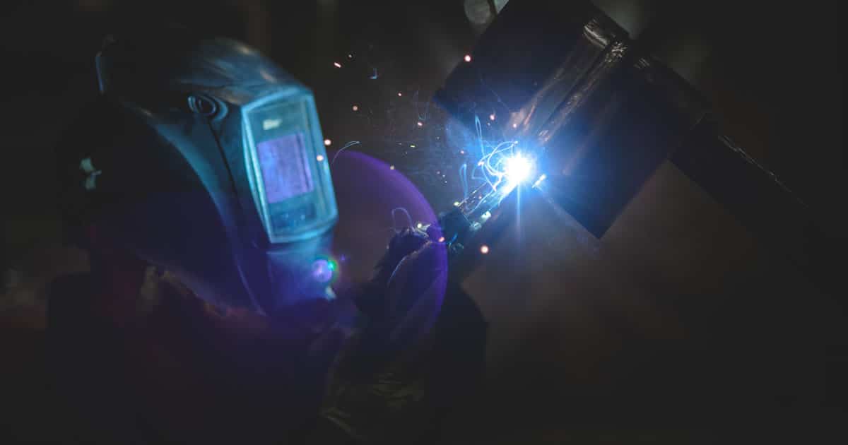 A fabricator welding a large metal part
